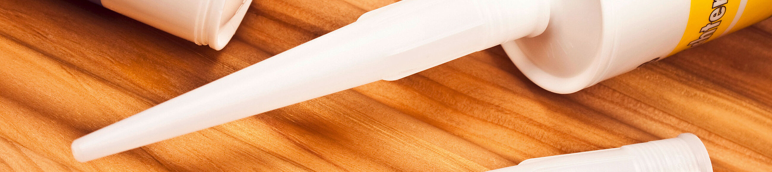 Zwei Acryl-Kartuschen auf einem Holzuntergrund