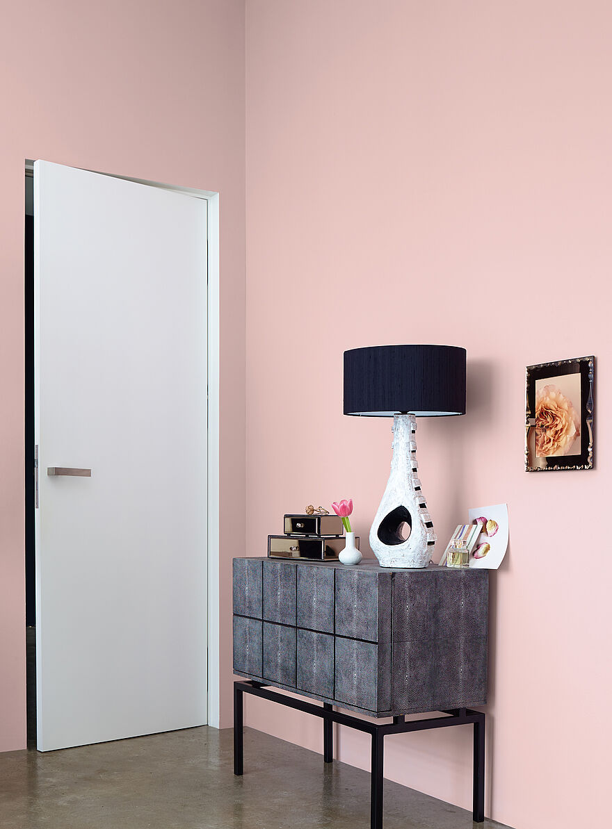 Rosé farbene Wand mit Dekorationen
