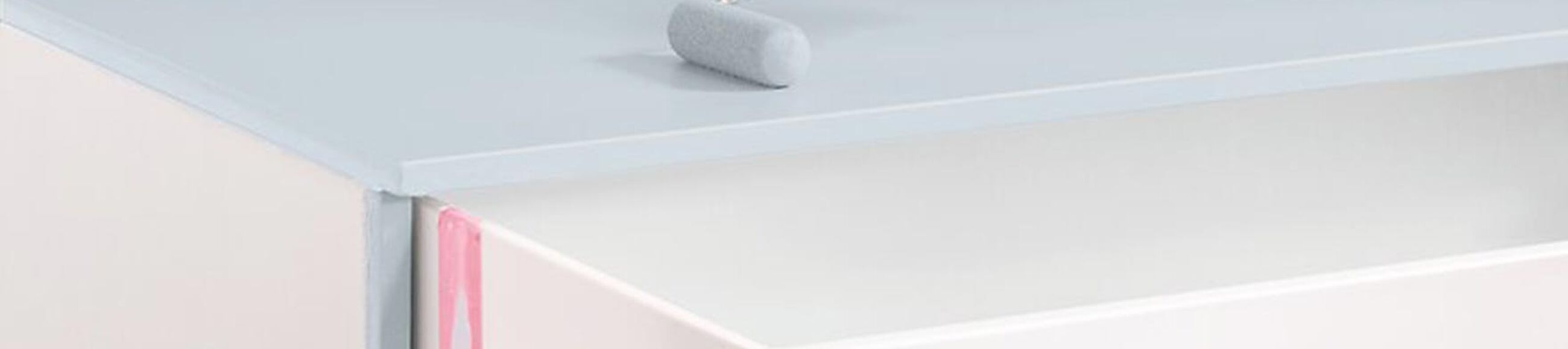 Eine Person lackiert eine Kommode mit hellblauem Lack