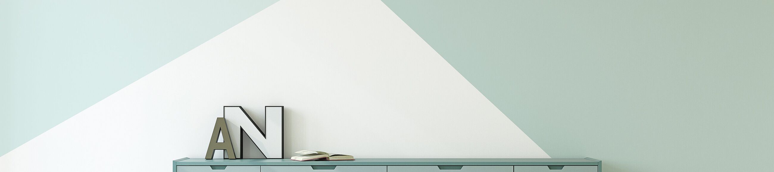 Sideboard in Mint vor einer Wand, gestrichen in zwei Mint-Tönen und einem Weiß-Ton