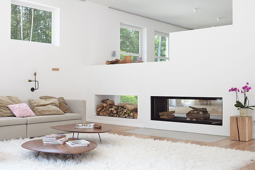 Modernes, weißes Loft mit Kamin, Fellteppich und beigen Sofa in Alpina Weiß.