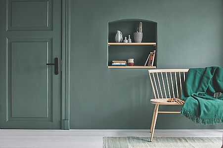 Dunkles Moosgrün. Ein in diesem zutiefst friedvollen und Geborgenheit schenkenden Farbton gestrichener Flur mit Holzbank.