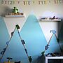 Eine creme-farbene Wand mit blauen Bergen in einem Kinderzimmer.