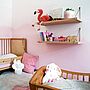 Kinderzimmer mit natürlichen Holzmöbeln in Rosa und Weiß.