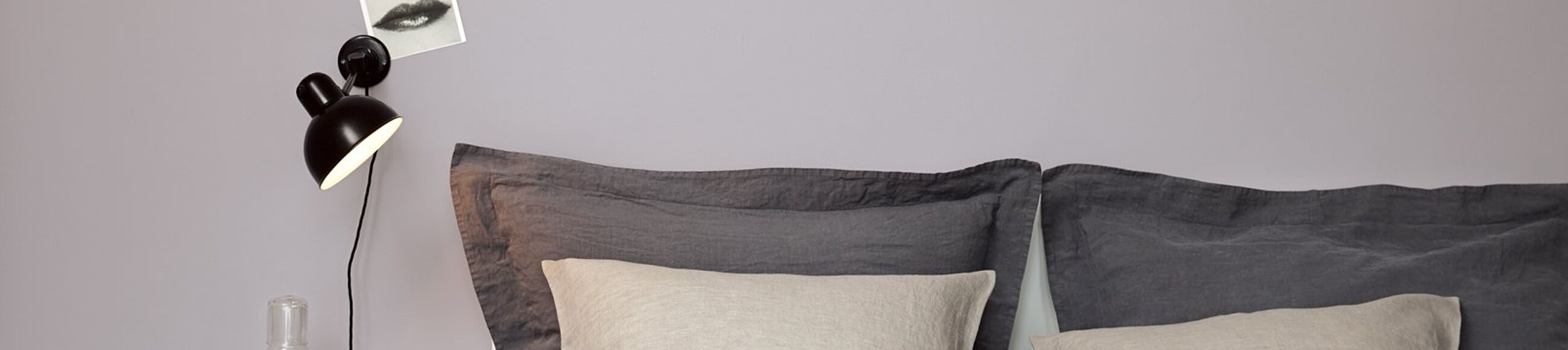 Kissen in Naturtönen und Tischlampe vor Wand in Mauve