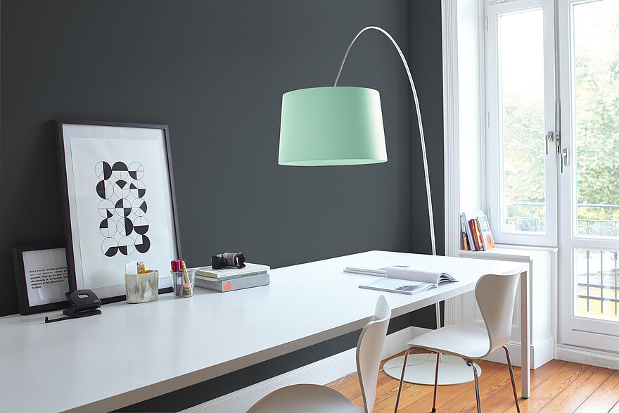 Heller Arbeitplatz mit grauer Wandfarbe und weißen Möbeln.