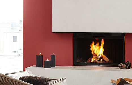 Kraftvolles Glutrot. Ein modernes, in diesem warmen und wohnlichen Farbton gestrichenes Wohnzimmer mit Kamin und Liege.