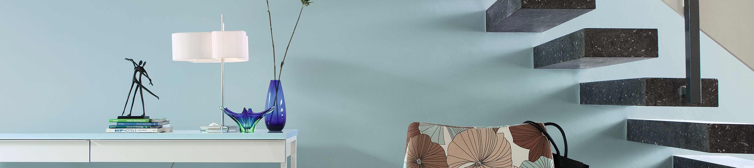 Ein Treppenaufgang mit einer azurblauen Wand 