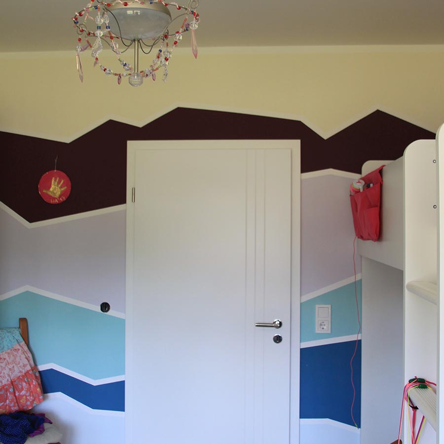 Helles Kinderzimmer mit dunkelblauen, hellblauen, grauen und braunen geometrischen Mustern.