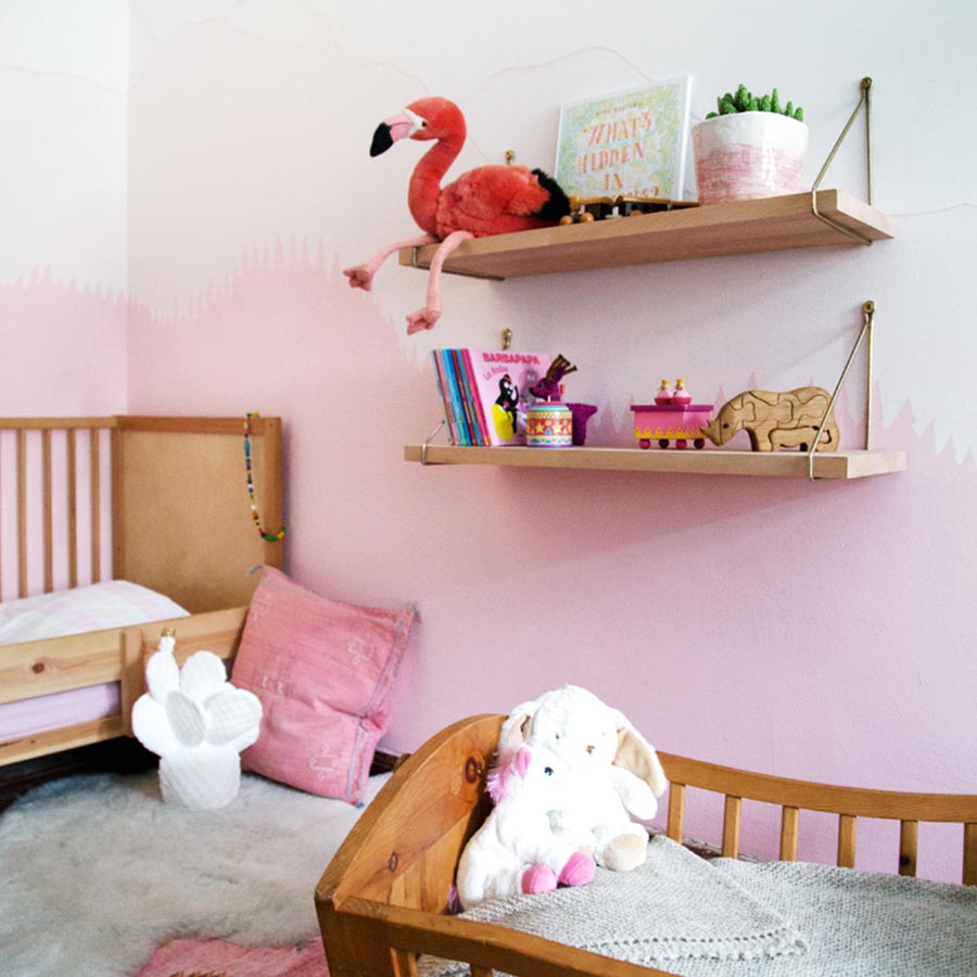 Kinderzimmer mit natürlichen Holzmöbeln in Rosa und Weiß.