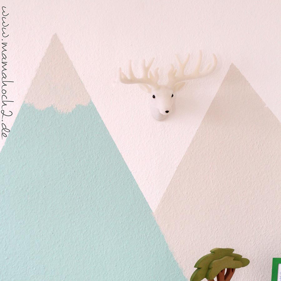 Blaue und beigene Berge als Wanddekoration im Kinderzimmer mit einer Hirschdekoration.