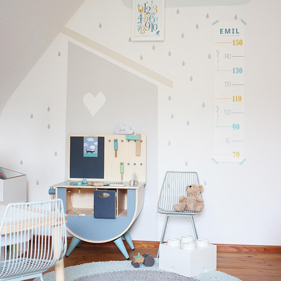 Ein helles, grau-weißes Kinderzimmer mit grauer Wanddekoration.