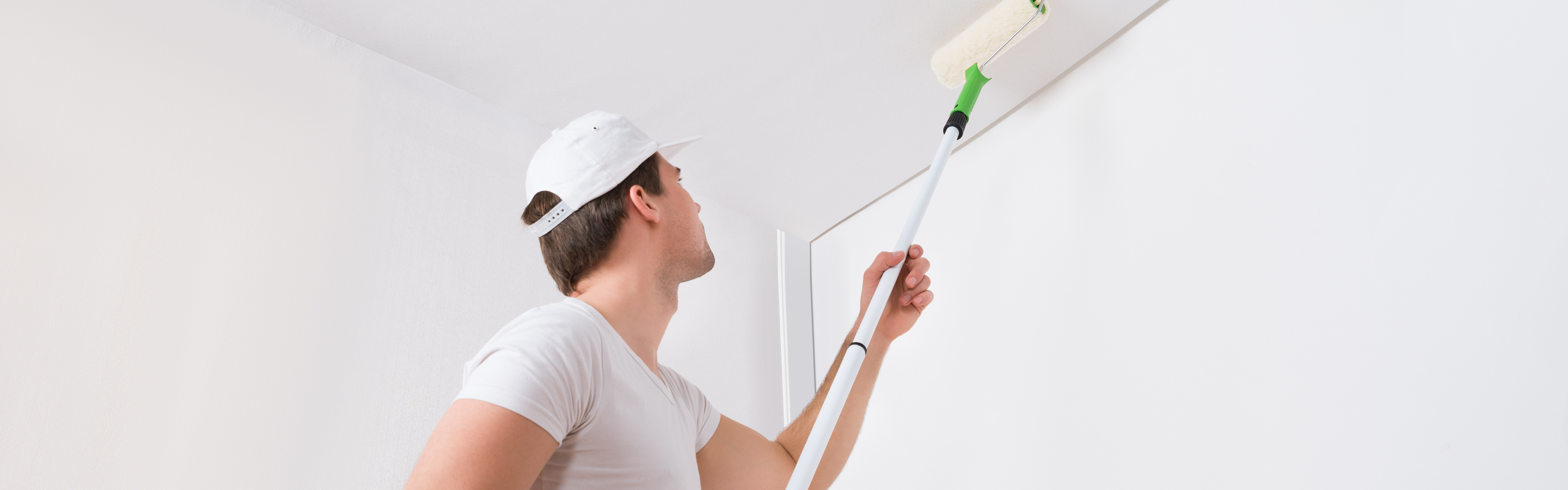 Ein Mann streicht eine Decke mit weißer Farbe