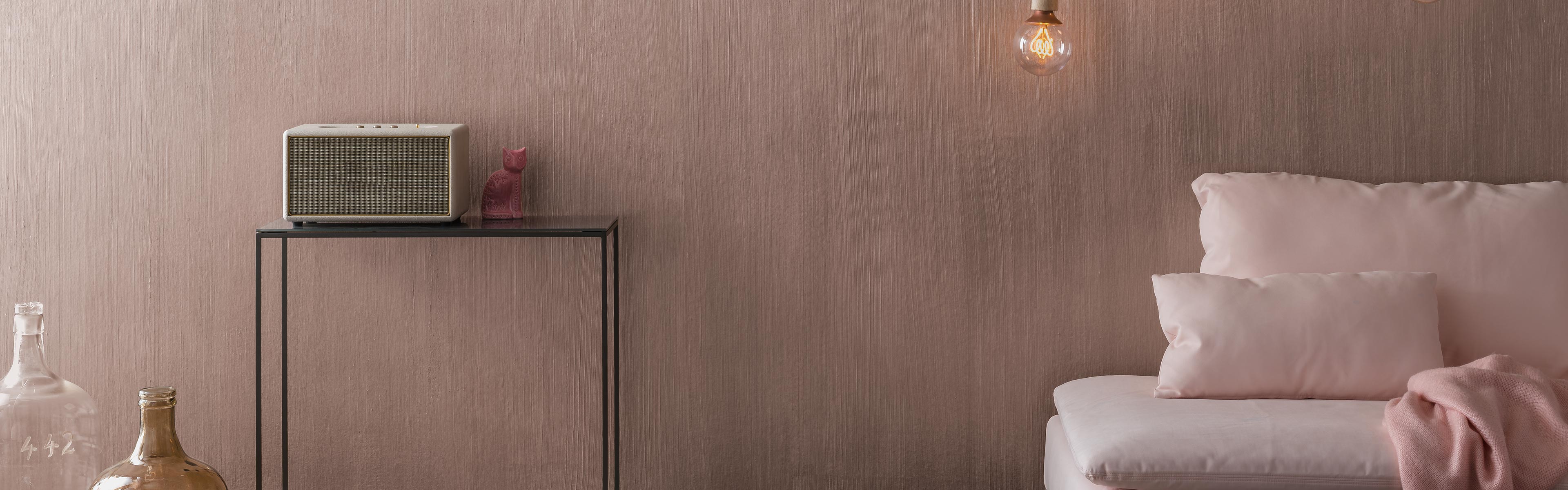 Ein Wohnzimmer mit einer Wand in Metallic-Roségold