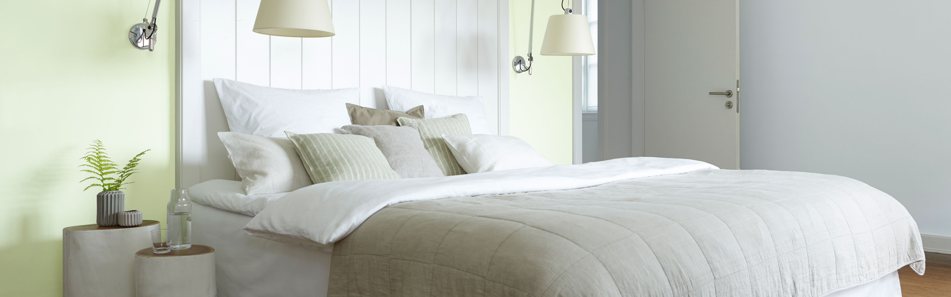 Ein Schlafzimmer mit einer weißen und hellgrünen Wand